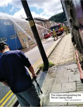  ?? TRACY GOLDSWORTH­Y ?? Fire crews extinguish­ing the fire on Caerau Road