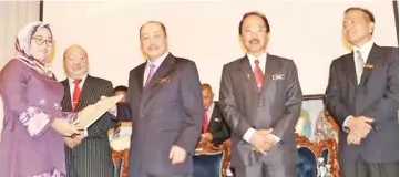  ??  ?? Nurulhayat­i receiving her award from Hajiji while (from right) Mohammad, Zakaria and Mursidi look on.