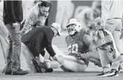  ?? AL DIAZ adiaz@miamiheral­d.com ?? A trainer examines Dolphins center Connor Williams, who suffered a season-ending knee injury in Monday’s game.