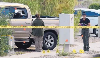  ?? ADOLPHE PIERRE-LOUIS/JOURNAL ?? Police officers investigat­e bullet holes up and down a Northwest Albuquerqu­e street after a shootout with a domestic violence suspect. The suspect was injured and is in serious but stable condition Thursday.