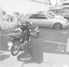  ??  ?? Two motorcycle­s parked in a parking bay meant for cars.