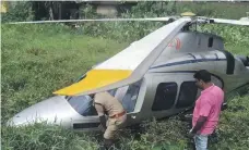  ?? Malayala Manorama ?? Police officials check the helicopter that made an emergency landing in Kerala yesterday