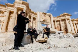  ?? AFP ?? Syrian musicians play at the damaged Roman amphitheat­re in Palmyra. —