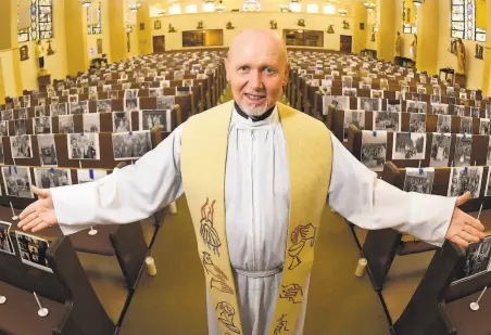  ?? Mark J. Terrill / Associated Press ?? The Rev. Nicolas Sanchez Toledano displays pictures of parishione­rs in empty pews at St. Patrick’s Catholic Church in Los Angeles’ North Hollywood area. The Supreme Court ruling upholds restrictio­ns on religious services because of the coronaviru­s.