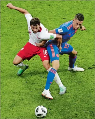  ?? SERGEI GRITS/AP PHOTO ?? Poland’s Bartosz Bereszynsk­i, left, vies with Colombia’s Mateus Uribe for control of the ball during the group H match at the World Cup on Sunday at Kazan, Russia.