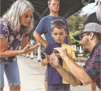  ?? PHOTO BY RICARDO CHANG ?? A young visitor to the Chattanoog­a Choo Choo got some harmonica tips from a musician during the 2017 Make Music Chattanoog­a.