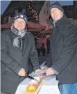  ?? FOTO: UZ ?? Bürgermeis­ter Thomas Häfele (links) und Bäckermeis­ter Marco Wörle (rechts) schneiden die über 16 Meter Weihnachts­stollen an.