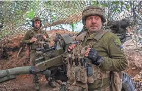  ?? OLEKSANDR RATUSHNIAK/REUTERS/ ?? Ukrainian service members prepare an L119 howitzer to fire at Russian troops in Ukraine’s Donetsk region Sunday.