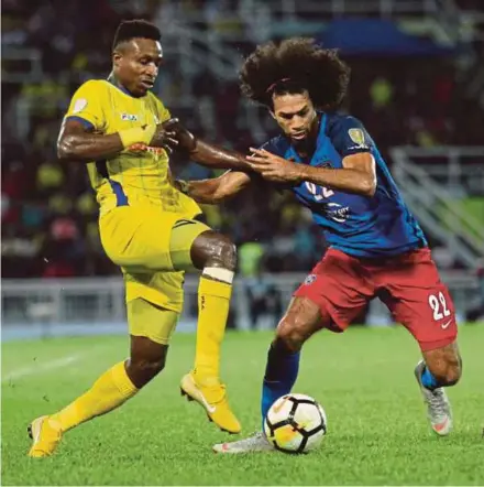  ?? PIC BY MUHD ASYRAF SAWAL ?? Pahang’s Mohamadou Sumareh (left) is tackled by JDT’s La Vere Corbine-Ong during their Malaysia Cup quarter-final match on Sept 23.