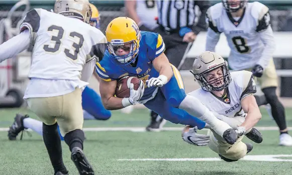  ?? KAYLE NEIS ?? Saskatoon Hilltops place kicker and clutch receiver David Solie gets tackled against the Edmonton Huskies at SMF Field on Sunday. The Toppers won 36-16.