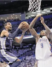  ?? Tony Gutierrez / Associated Press ?? Memphis’ Mike Conley looks intimidati­ng against the Thunder’s Serge Ibaka on his way to 26 points.