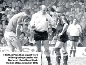  ??  ?? > Ref Les Peard has a quiet word with opposing captains Phil Davies of Llanelli and Kevin Phillips of Neath back in 1989