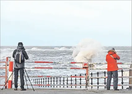  ?? EFE ?? Inglaterra. Dos fotógrafos capturan la intensidad de las olas desde el paseo marítimo de New Brighton.