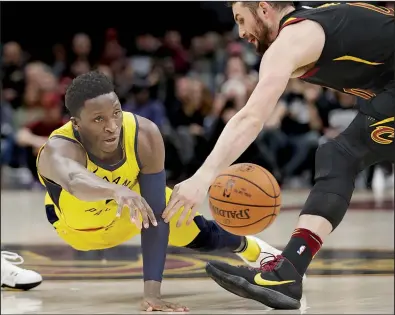  ?? AP/TONY DEJAK ?? Indiana Pacers guard Victor Oladipo (left) passes as Cleveland Cavaliers center Kevin Love defends in the second half of Game 1 of Sunday’s NBA Eastern Conference first-round series in Cleveland. Oladipo finished with 32 points, 6 rebounds, 4 assists...