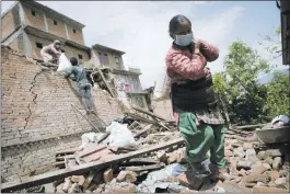  ?? NICOLAS ASFOURI/ AGENCE FRANCE- PRESSE VIA GETTY IMAGES ?? Residents carry their belongings from their destroyed house Wednesday in Harisddhi, on the outskirts of Kathmandu, Nepal. Rescuers are facing a race against time to find survivors of a mammoth 7.8- magnitude earthquake that killed more than 5,000...