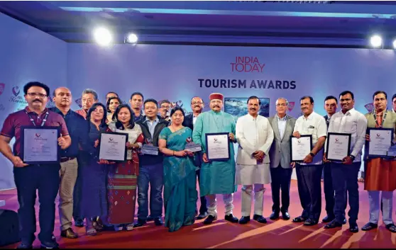  ??  ?? TRAVELLERS’ CLUB Union tourism minister Dr Mahesh Sharma (centre, in white) and India Today Group chairman Aroon Purie with the award winners