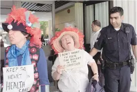  ??  ?? Grannies Fran Thoburn, left, and Freda Knott are escorted out of the Ministry of Health building on Blanshard Street in 2002 after protesting health-care cuts.