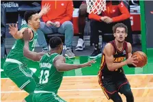  ?? CHARLES KRUPA/ASSOCIATED PRESS ?? Atlanta’s Trae Young, right, looks to score in the face of defensive pressure from Boston’s Tristan Thompson (13) on Wednesday night. Young had 40 points in the Hawks’ victory.