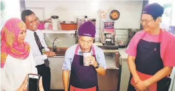  ??  ?? Naroden (centre) gets to taste his smoothie at the Cool Blog outlet at Kuching Internatio­nal Airport. Leong is seen on the right.