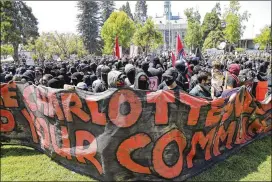  ??  ?? Antifa protesters dressed in black carry a large banner during a “Stand Against Hate” rally at Martin Luther King Jr. Civic Center Park in Berkeley, Calif., on Sunday.