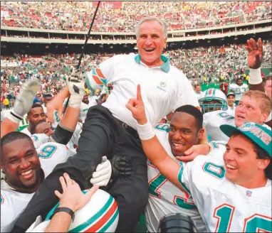  ?? (AP/George Widman) ?? Former Miami Dolphins Coach Don Shula is carried on his team’s shoulders after a 1993 victory over the Philadelph­ia Eagles, the 325th of his career. Shula, the winningest coach in the league who led the Dolphins to a perfect season in 1972, died Monday at his South Florida home at age 90.