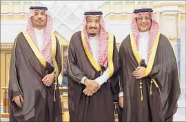  ?? Saudi Press Agency ?? SAUDI KING Salman is f lanked by Prince Khalid bin Ayyaf al-Muqrin, the new national guard chief, left, and Mohammad Tuwaijri, the new economy minister.