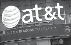  ?? Associated Press file photo ?? ■ The AT&T logo is positioned above one of its retail stores on Oct. 24, 2016, in New York. Opening arguments in the federal government’s case to block AT&T’s efforts to gobble up Time Warner began Thursday.