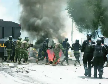  ?? EFE ?? Policías antidistur­bios se enfrentan a los manifestan­tes en las calles de Quito