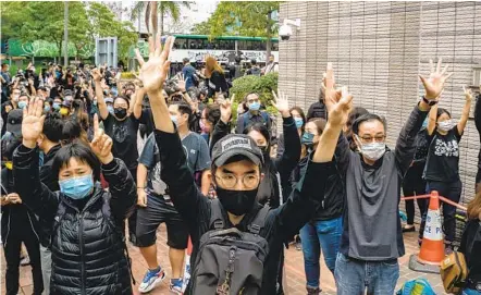  ?? ANTHONY KWAN GETTY IMAGES ?? Pro-democracy protesters gather outside the West Kowloon court Monday in Hong Kong. The protest took place during court appearance­s by dozens of dissidents charged with subversion in the largest use of Beijing’s sweeping new national security law to date.