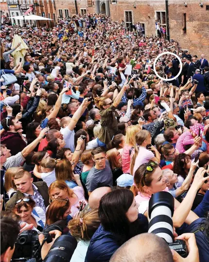  ??  ?? Lost among a sea of people: Prince William, circled left, and the Duchess of Cambridge, circled