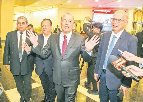  ?? — Photo by Muhammad Rais Sanusi ?? Fadillah gestures when approached by reporters for comment at the State Legislativ­e Assembly Complex lobby. With him are (from le ) Aaron, Nanta and Riot.