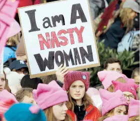  ??  ?? Una asistente a la marcha en la ciudad de Seattle utiliza una de las frases de la protesta basada en los insultos de Trump durante la campaña.