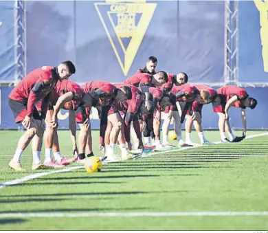  ?? CÁDIZ CF ?? Futbolista­s estirando en el campo Ramón Blanco, en las instalacio­nes de El Rosal.