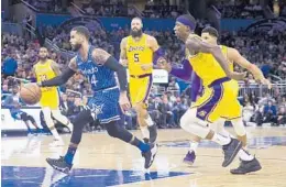  ?? WILLIE J. ALLEN JR./AP ?? Orlando Magic guard D.J. Augustin dribbles past Los Angeles Lakers guard Kentavious Caldwell-Pope, right, and center Tyson Chandler (5) during the Magic’s win over the Lakers on Saturday night at Amway Center.