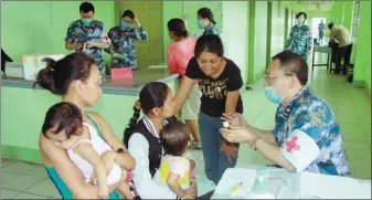  ?? WANG JINGLONG / FOR CHINA DAILY ?? A Chinese doctor provides advice to mothers at a temporary medical facility in Tacloban, Philippine­s.