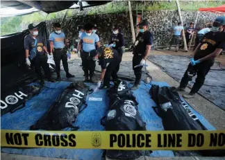  ?? Photo by Jean Nicole Cortes ?? DUG UP. Cadavers retrieved at the landslide-stricken Barangay Ucab in Itogon Benguet are brought to the command center to be properly identified by Scene of the Crime Operatives and their relatives.