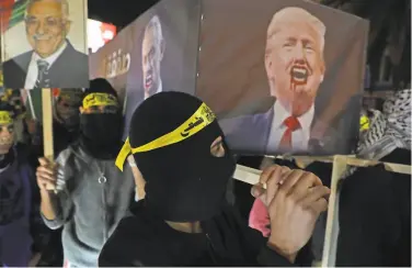  ?? Jaafar Ashtiyeh / AFP via Getty Images ?? Palestinia­ns carry a mock coffin of President Trump during a protest in the West Bank city of Nablus.