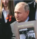  ?? ?? Putin holds a portrait of his father, war veteran Vladimir Spiridonov­ich Putin, as he takes part in the Immortal Regiment march on Victory Day, which marks the 77th anniversar­y of the victory over Nazi Germany