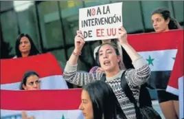  ?? AP ?? A protester in Chile displays a paper that reads in Spanish ‘No interventi­on of the US’ in Syria.
