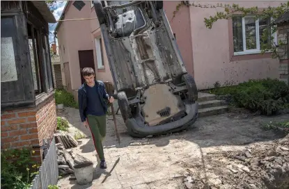  ?? The Associated Press ?? A resident carries a shovel to clear rubble from his house in Kharkiv, Ukraine, on Monday.