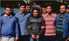  ?? AFP ?? Police escort alleged militant Jahangir Alam (centre) in Dhaka yesterday, after his arrest in connection with a deadly siege at a Dhaka cafe that left 22 hostages dead last year.