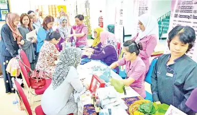  ??  ?? Women taking the free health screening and pap smear test in Sabah State Library yesterday.