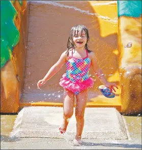  ?? Photos by Terrance Armstard/News-Times ?? Splash: Three-year-old Crystal Smith of Camden splashes through the water while attending opening day for the Playscape Splash Pad in the Murphy Arts District on Friday.