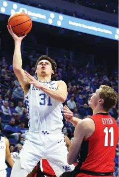  ?? AP PHOTO/JAMES CRISP ?? Kentucky’s Kellan Grady shoots while defended by Georgia’s Jaxon Etter during the first half of Saturday’s SEC matchup in Lexington, Ky. Kentucky led 40-37 at halftime but shot 63% after the break to pull away for the win.