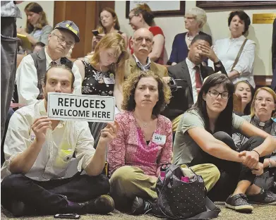  ?? STAFF FILE PHOTOS, ABOVE, BY PATRICK WHITTEMORE; LEFT, BY CHRIS CHRISTO ?? SHOWING SUPPORT: Seated attendees, above, show their support for classifyin­g Massachuse­tts a sanctuary state earlier this month. Somerville, left, and Mayor Joseph A. Curtatone, far left, have long touted their sanctuary status.