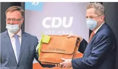  ?? FOTO: DPA ?? Nach seiner Nominierun­g erhielt Maaßen (r.) am Freitag von Ralf Liebaug, dem CDU-Kreisvorsi­tzenden von Schmalkald­en-Meiningen, eine Tasche.