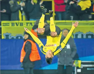  ?? BERND THISSEN/DPA VIA AP ?? Pierre-Emerick Aubameyang somersault­s after scoring Dortmund’s fourth goal — his third of the game — during Wednesday’s 4-0 victory over Benfica in their Champions League last-16, second-leg match in Dortmund, Germany. The host reached the...