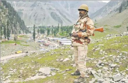  ??  ?? A paramilita­ry personnel standing guard at a vantage point overlookin­g the base camp in Baltal, 15 km from Sonamarg, on Wednesday, as the first batch of pilgrims arrived for this year’s Amarnath Yatra. Security has been tightened for the visit to the shrine. NITIN KANOTRA/ HT