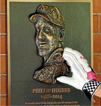  ?? GETTY IMAGES ?? Australian cricketer Dave Warner touches a bronze plaque of the late Phillip Hughes at the Sydney Cricket Ground.