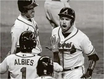  ?? Godofredo A. Vásquez / Staff photograph­er ?? Travis d’Arnaud, right, celebrates with teammates after his three-run shot in the seventh put the Braves up for good.